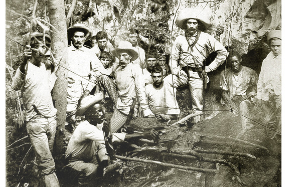 Fotografía de un grupo de insurrectos cubanos asando un cerdo en la manigua